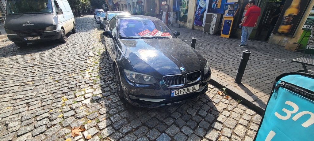 Front-side view of BMW 318i Convertible rental car in Tbilisi.
